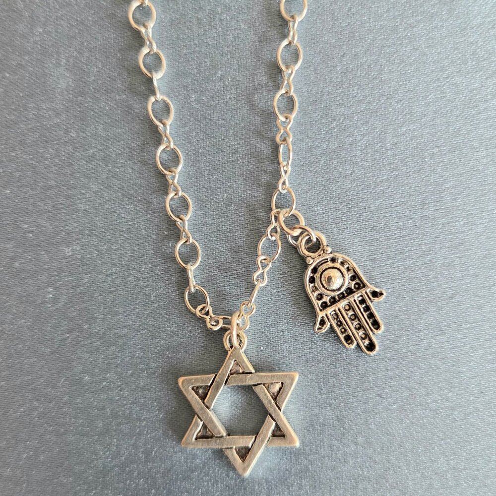 Handmade silver color metal charm necklace with Star of David and Hamsa hand.